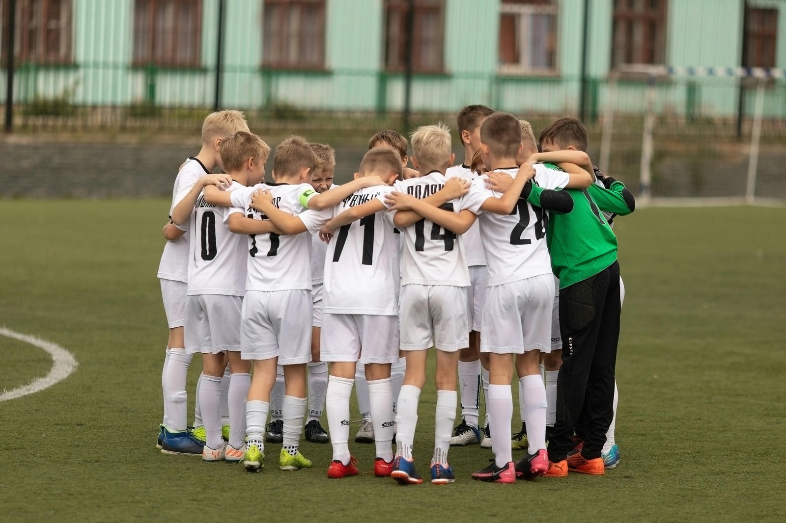 Youth sports team in a huddle on the field